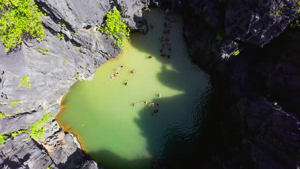 Chinese and Korean tourists swim inside the small secret lagoon surrounded by the rocky mountains