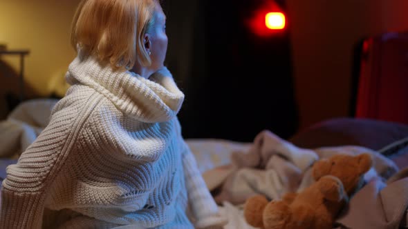 Frustrated Anxious Ukrainian Woman on the Left in Bomb Shelter with Airraid Alert Lamp Flashing at