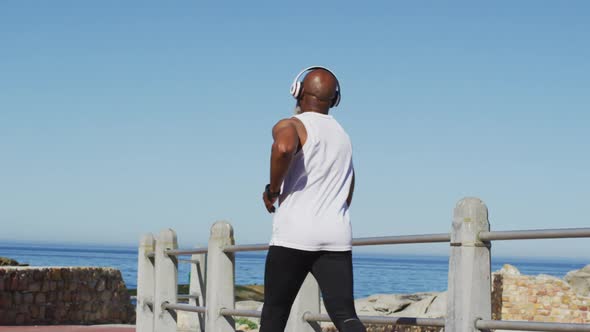 Senior african american man exercising running on road by the sea