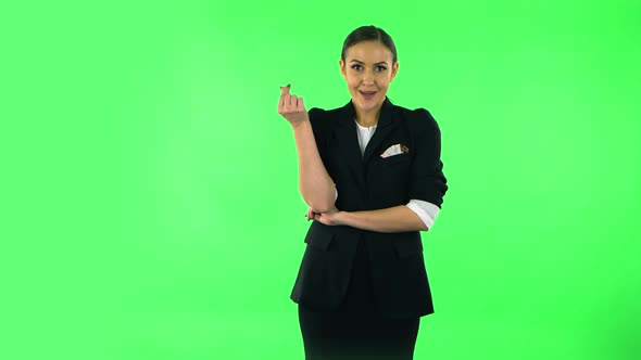 Cute Girl Smiles and Showing Heart with Fingers Then Blowing Kiss. Green Screen