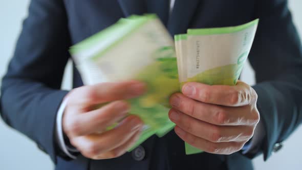Formally Dressed Man Counting Euro Banknotes