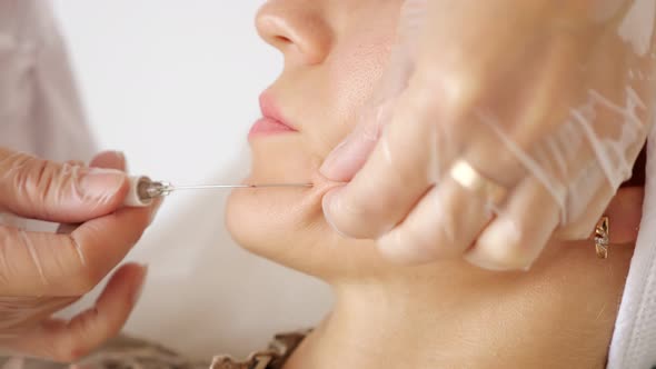 Professional Cosmetic Surgeon Injects Young Woman Cheek
