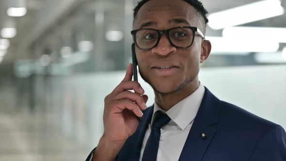 Portrait of Cheerful African Businessman Talking on Smartphone