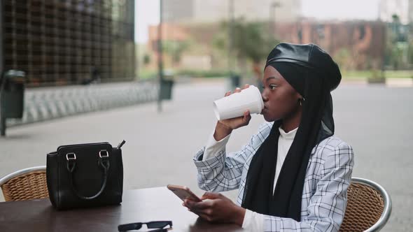 Trendy Muslim Woman Resting in Street Cafe