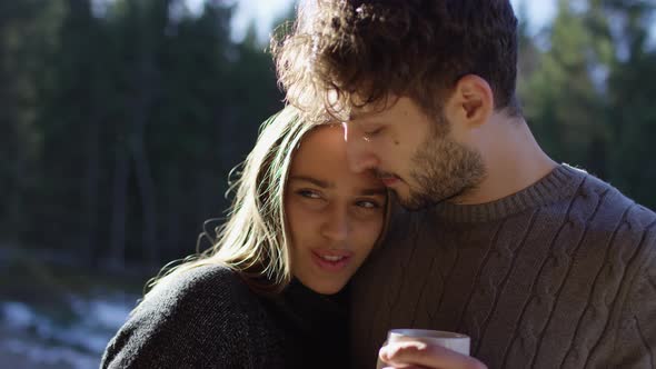 Couple hugging and holding a mug