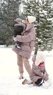 Adorable Mother and Toddler Kids Have Fun Togtether Outside in Sunny Frosrty Day