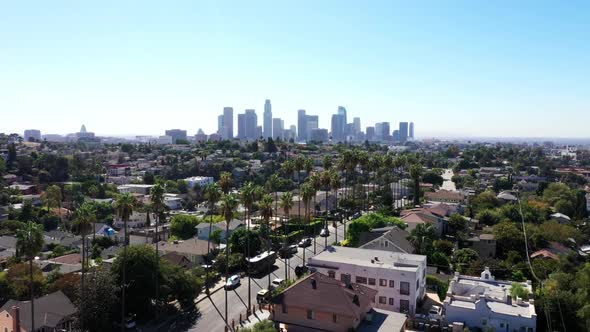 Beautiful drone shot from a neighborhood of Los Angeles, California showing palm trees and the city
