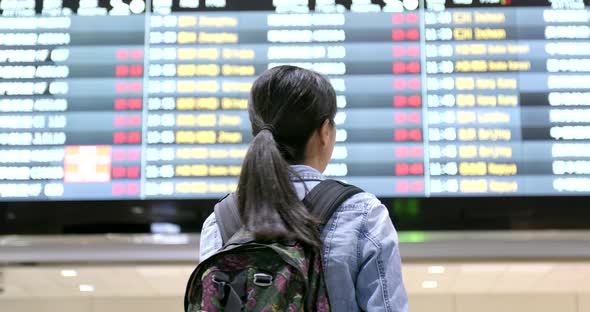 Woman checking the flight number in the airport