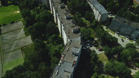 Multi Storey Buildings And A Large Green Area. An Old School Stadium In A City Block.