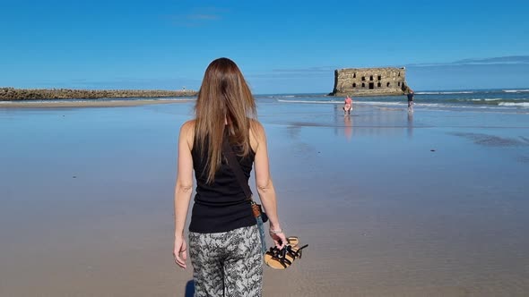 Elegant beautiful girl overlooking the bay in .Tarfaya,, Marroco 4K videos. walking along the sandy