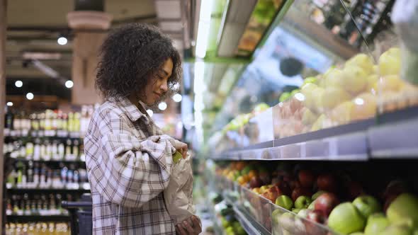 Cheerful Woman Choosing Fresh Apples in Supermarket Into Paper Bag