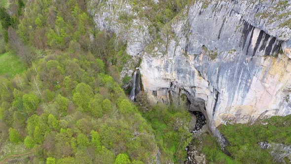Flying Above a Waterfall and Big Cave Entrance, Romania, Aerial View