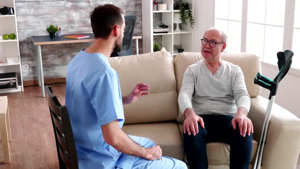 Young Bearded Doctor Talking with Senior Man