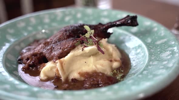 Close-up of mashed potatoes and chicken leg in sauce