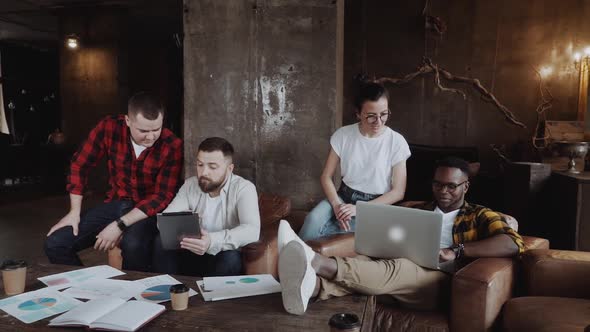 Group of Casually Dressed Businesspeople Discussing Ideas in the Office