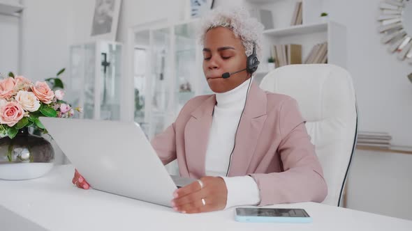 Young African American Woman in Headset Making Via Video Call in Laptop