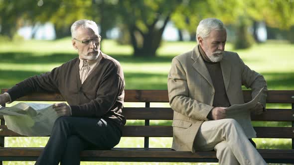 Two Offended Old Men Reading Newspapers, Sitting on Bench in Park, Quarrel