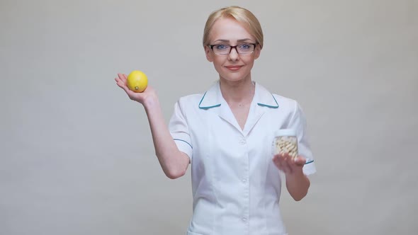 Nutritionist Doctor Healthy Lifestyle Concept - Holding Organic Lemon Fruit and Jar of Vitamin Pills