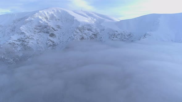 Fog covering Frozen mountain peaks during winter