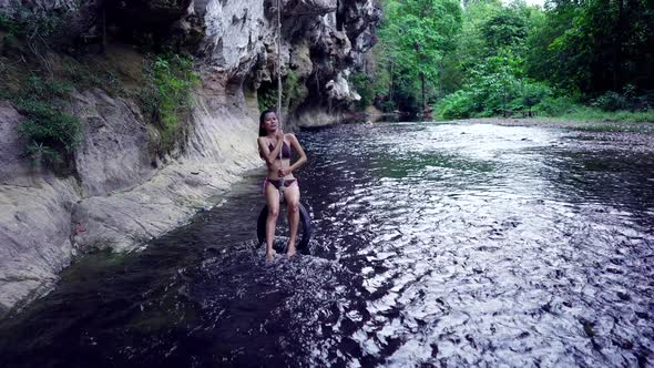 Cute Smiling Asian Girl in Bikini Chilling on a Rope in the River Thailand