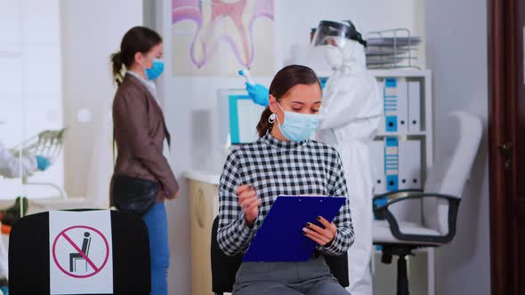 Patient with Face Mask Writing on Registration Form