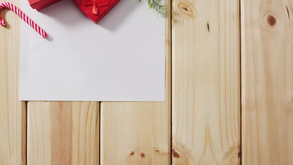 Video of christmas decorations with white card and copy space on wooden background