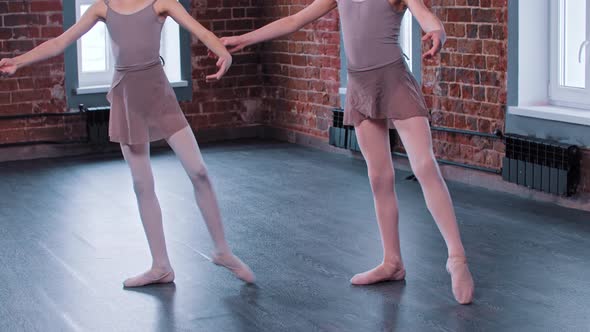Two Ballerina Girls Training in a Dance Studio  Training the Leg Move