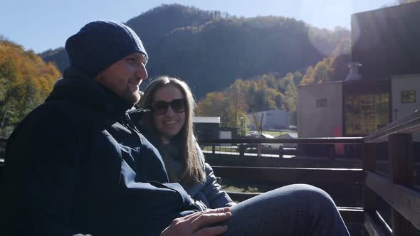 Happy Couple Sitting on a Wooden Bench Two Tourists on a Hike Vacation Travel Panoramic Beautiful