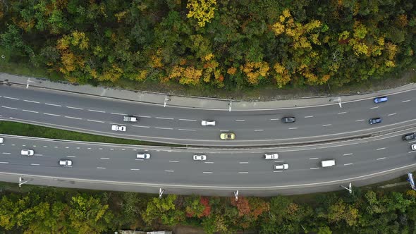 Aerial View of a Highway with Cars Driving Along It in a Autumn Forest