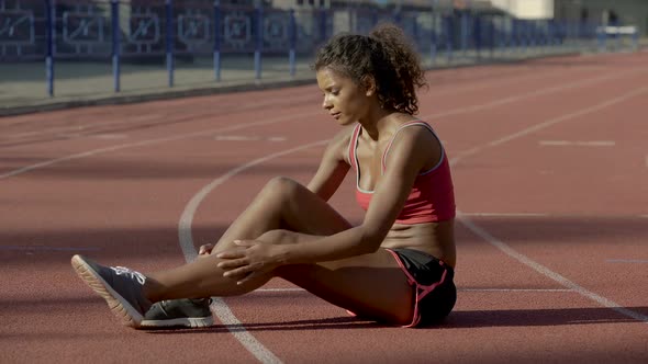 Cute Athletic Girl Massaging and Rubbing Her Tired Feet After Workout at Stadium