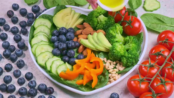Broccoli, avocado, berries and nuts salad in white plate.