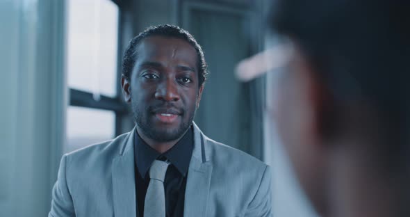 African businessman smiling and spaking with female colleague