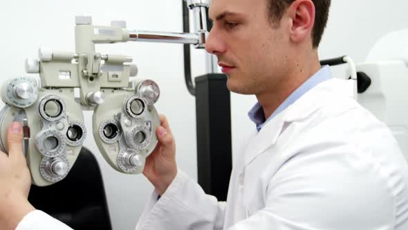 Smiling optometrist adjusting chiropter