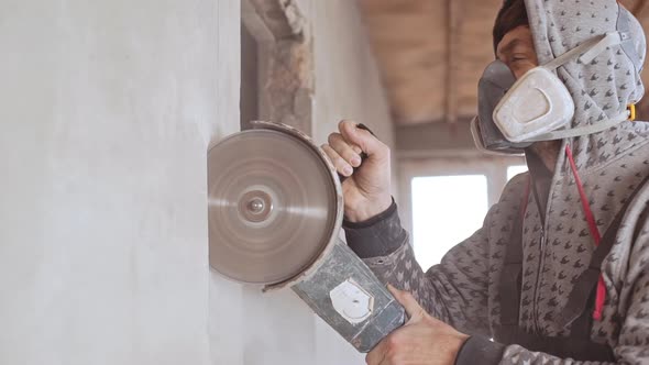 Caucasian Male Worker Wearing Respirator Using Angle Grinder in Slowmotion