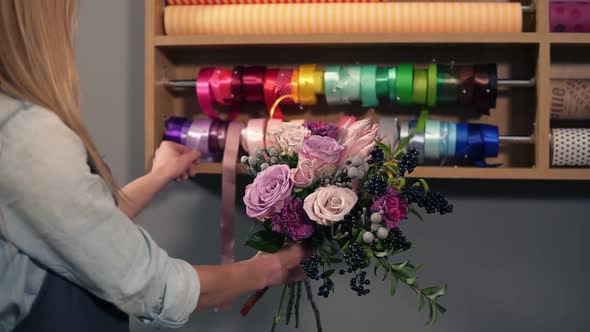 Back View of Female Blonde Florist Arranging Modern Bouquet and Choosing the Perfect Riband for It