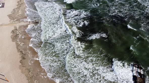 Aerial Drone View Flight Over Sea Waves That Roll Onto Sandy Shore