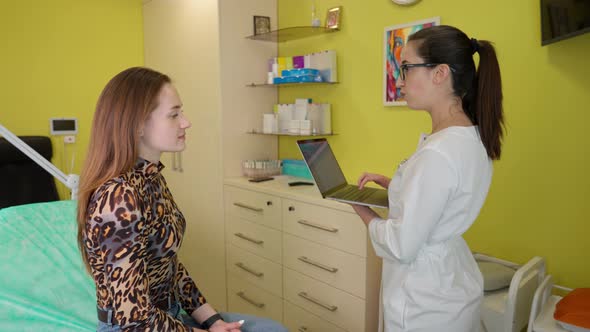 Young Woman Client Talking with Female Beautician While Visiting Beauty Clinic