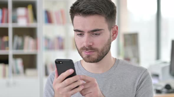 Portrait of Serious Young Man Using Smartphone