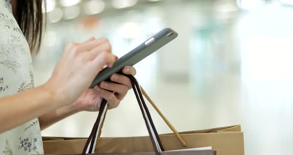 Woman using mobile phone in shopping mall