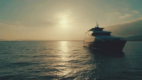 Drone footage during sunrise from an elegant boat near the coast.