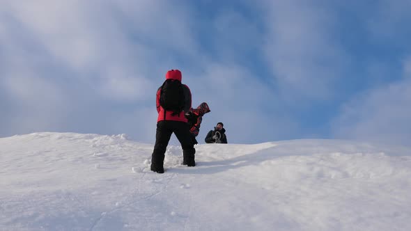 Alpenists Team in Winter Down Rope From Mountain. Travelers Descend By Rope From a Snowy Hill