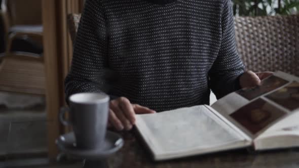 Man Reflected In Table With Photograph Album