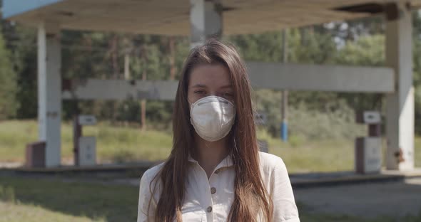 Portrait of Young Woman Wearing Protective Virus Mask on Abandoned Industrial Background. Front View