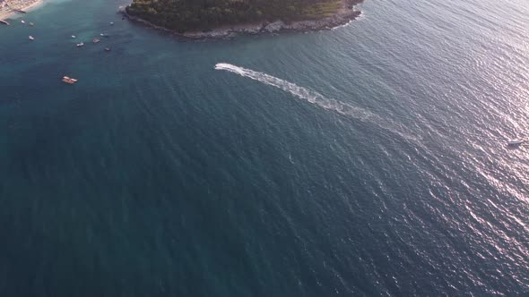 Aerial View Over Man Speeding On Jet Ski Tourist Attraction Exotic Tropical Island Shore Beach At