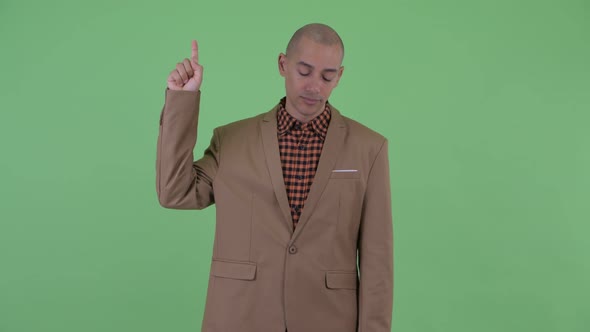 Tired Bald Multi Ethnic Businessman Pointing Up