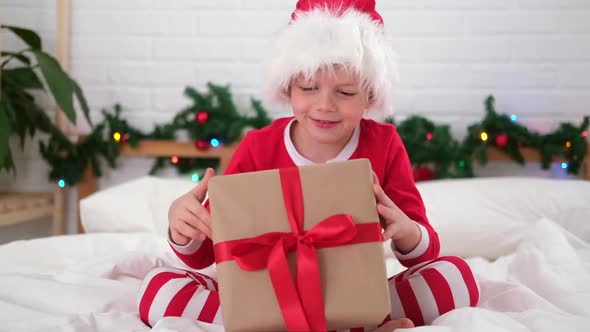 Little Boy Shakes Gift Box to Find Out What is Inside