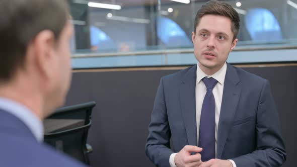 Rear View of Businessman Talking to Colleague