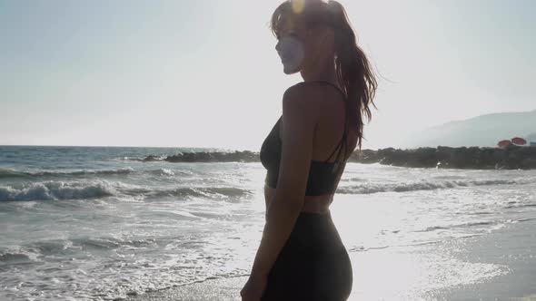 Athletic woman at the beach relaxing and enjoying the view after her workout