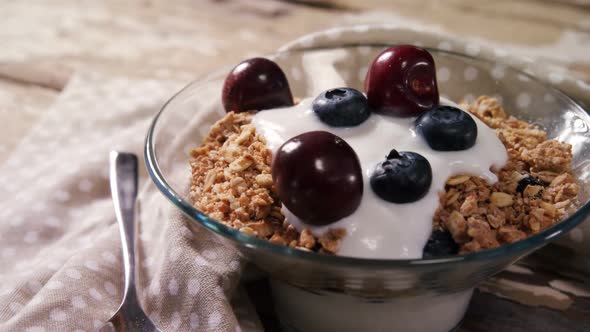 Bowl of yogurt muesli, cherries and blueberries for breakfast 4k