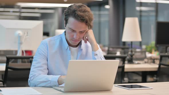 Tired Man Taking Nap While Sitting in Office with Laptop